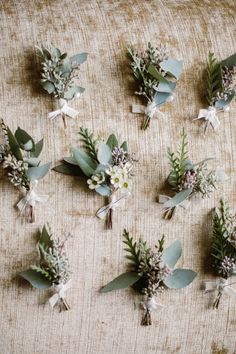 a bunch of flowers that are sitting on a table cloth with ribbons and bows around them