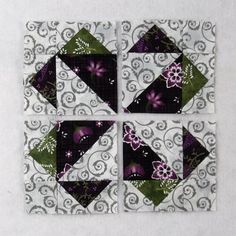 a quilted square with purple and green flowers on it