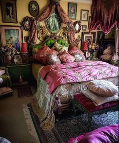 a large bed sitting in a bedroom next to pictures on the wall and pillows below it