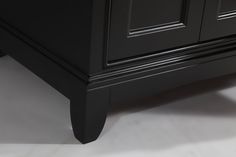 a close up view of a bathroom vanity with white flooring and black cabinetry