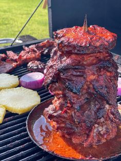 a large piece of meat is being cooked on a bbq grill with pineapple slices