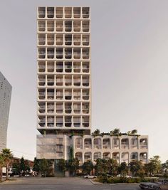 a tall building with lots of windows and balconies on the top floor is surrounded by palm trees