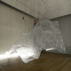 a large white piece of paper sitting on top of a hard wood floor next to a wall