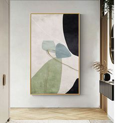 an abstract painting hangs on the wall next to a door in a white walled room