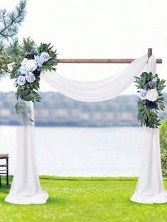 an outdoor wedding setup with white drapes and blue flowers