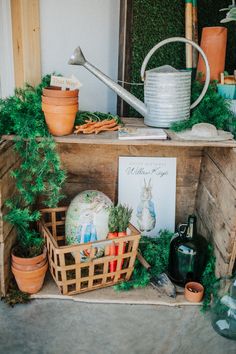 an assortment of plants and gardening implements on a wooden crate in front of a house