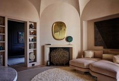 a living room with a couch, fireplace and bookcases in front of a mirror