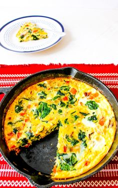 an omelet with spinach and cheese in a cast iron skillet on a table