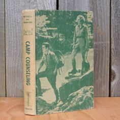 an old book sitting on top of a wooden table next to a wood plank fence