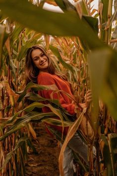 a woman standing in the middle of a corn field