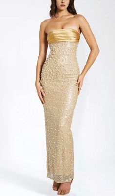 This stunning gold satin maxi dress is adorned with intricate sequins and delicate pearls, creating a truly luxurious and exclusive piece. Its flowing silhouette and exquisite detailing make it the perfect choice for any glamorous occasion. Elevate your wardrobe with this opulent dress. Materials: Sequin & Pearl Beaded Fabric / Double Duchess Satin Length from underarm: Approx 52 inch / 132 cm Stretch Factor: Non Stretch Clean: Dry-clean only Colour may vary due to lighting on images. The produc Gold Formal Dresses Long, Gold Beaded Bridesmaid Dresses, Gold Sequin Maxi Dress, Long Pearl Dress, Pearl Maxi Dress, Embellished Midi Evening Dress For Prom Season, Gold Embellished Sleeveless Sequin Dress, Glamorous Satin Gala Gown, Glamorous Satin Gown For Gala