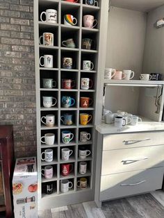 there are many mugs on the shelves in this room, and one is full of them