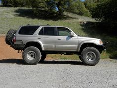 a silver truck parked on top of a dirt road