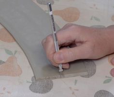 a person holding a pen and writing on a piece of paper with an eraser