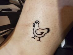 a small chicken tattoo on the ankle