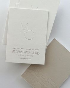 three folded cards with the letter m on one side and an envelope in the other