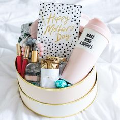 a gift basket with coffee, makeup and other items in it on a white sheet