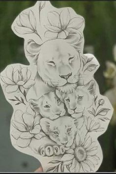 a hand holding up a sticker with lions and flowers on the back of it