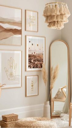 a white room with pictures on the wall and a chair in front of a mirror