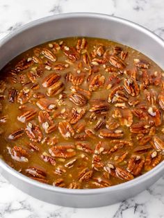 a pan filled with pecans sitting on top of a marble counter