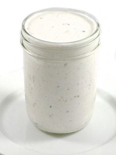 a white plate topped with a glass jar filled with liquid