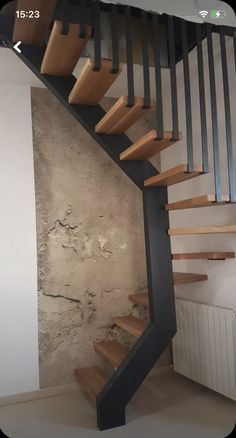 an image of a wooden stair case in a room with concrete walls and flooring