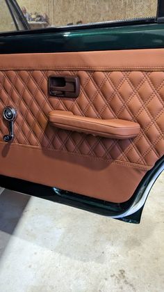 the interior of a car that is tan and black with brown leather trimmings