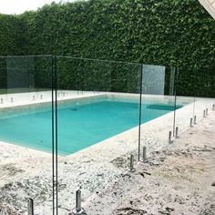 an empty swimming pool surrounded by glass fencing