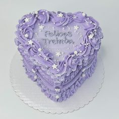 a heart shaped cake with purple frosting and stars