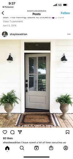 the front door is white and has potted plants