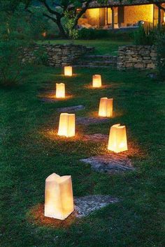 some paper lanterns sitting in the grass with one light on it's side and another lit up