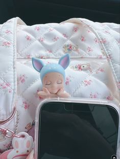 a cell phone sitting on top of a table next to a stuffed animal and other items