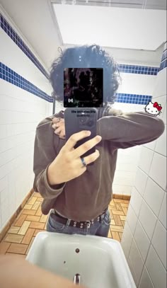 a person taking a selfie in a bathroom mirror