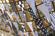 some black and white flags hanging from a wooden fence with polka dots on the ribbon