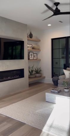 a living room filled with furniture and a flat screen tv mounted on the wall above a fireplace