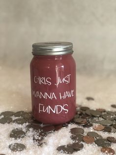 a jar filled with lots of coins sitting on top of a pile of white snow