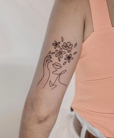 a woman's arm with a flower tattoo on the left side of her arm