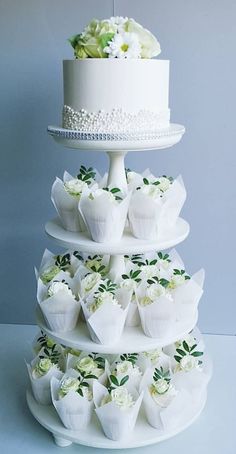 a three tiered cake with white flowers on it