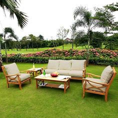 an outdoor living area with lawn furniture and flowers in the background