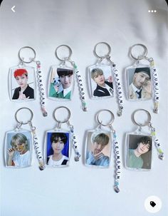 six keychains with pictures of the same person hanging from each other on a white surface