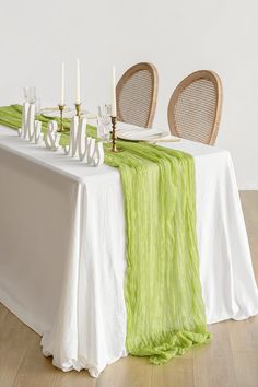 the table is set with white and green linens