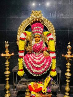 the statue is decorated with flowers and candles