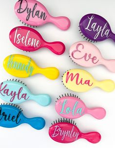 colorful hair combs with names on them sitting next to each other in front of a white background