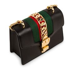 The Gucci Sylvie is one of those bags that became a classic the moment it landed in stores. Featuring the brand’s signature green and red front fabric stripe and a charming gold tone hardware chain strap, this mini Gucci baby is an absolute must-have. With a gold buckle chain prominently depicted on the front flap, the Sylvie is luxurious, glamorous and the perfect accessory to compliment to anything you may have in your wardrobe. Whether you dress the Sylvie up or down, you can be sure this “un Gucci Sylvie, Mini Chain Bag, Gucci Baby, Handbag Collection, Bags Luxury, Dior Shoes, Mini Shoulder Bag, Chain Bag, Green And Red