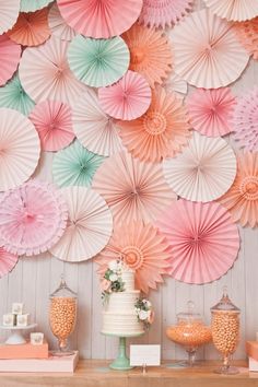 a table topped with lots of pink and green paper umbrellas