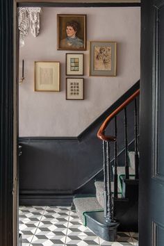 a staircase with pictures on the wall above it