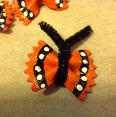 an orange and black hair bow with white polka dots on it, sitting on the ground