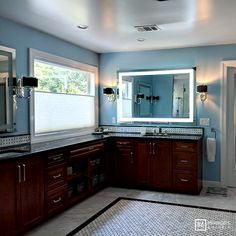 a large bathroom with blue walls and tile flooring on the floor, along with double sinks