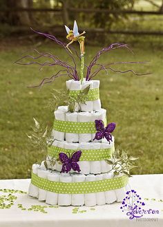 a cake made out of toilet paper with purple and green decorations on the top tier