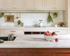 a bowl of fruit sitting on top of a kitchen counter